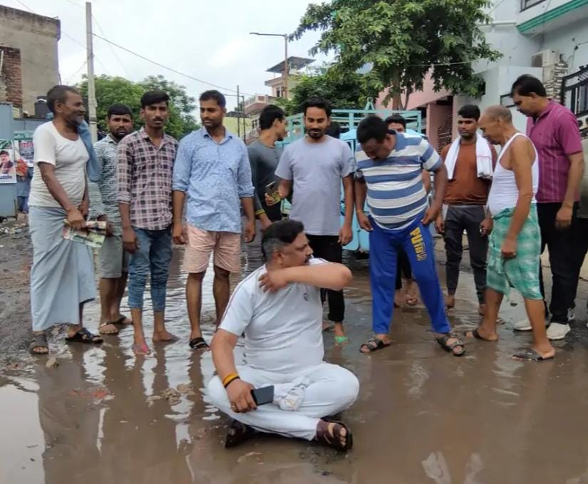  Agra News:सड़क पर गंदे पानी में बैठकर लोगों का विरोध प्रदर्शन, मेयर पर लगाया विकास न करने का आरोप